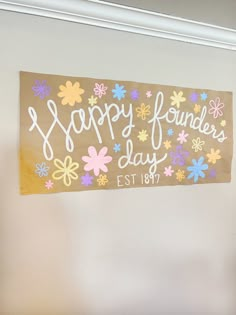 a sign that says happy founder's day with flowers on it hanging from the wall