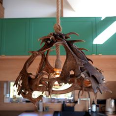 a chandelier made out of antlers hanging from a ceiling in a kitchen