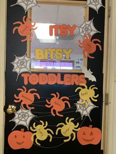 a door decorated for halloween with spider webs and bats