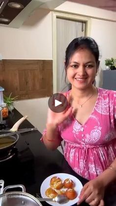 a woman in pink shirt holding a plate of food