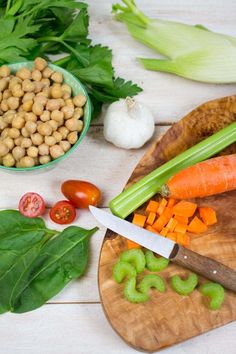 carrots, celery, and chickpeas are on a cutting board