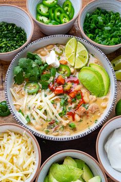 several bowls filled with different types of food next to limes and sour cream sauce