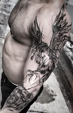 a man with a bird tattoo on his arm and shoulder is posing for the camera