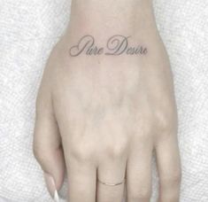 a person with a small tattoo on their left hand and the word love is written in cursive font