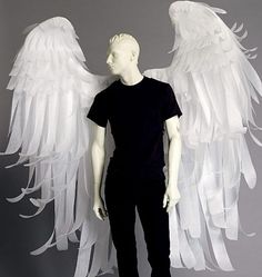 a male mannequin dressed in black with white wings