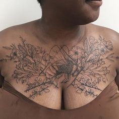 a woman with tattoos on her chest is looking at the camera