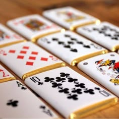 several playing cards are arranged on a wooden table with gold trimmings and black and white designs