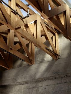 an unfinished ceiling with exposed pipes and wooden beams