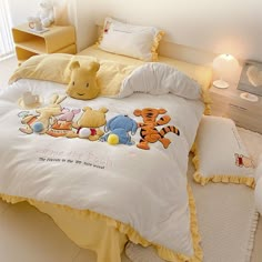 a bed with winnie the pooh comforter and pillows