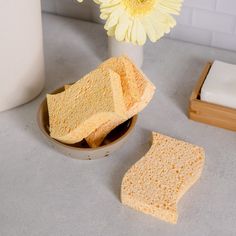 two pieces of bread sitting in a bowl next to a flower