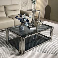 a glass coffee table sitting on top of a rug in front of a white couch