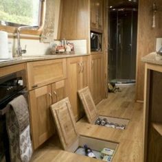 the inside of a motor home with wood flooring and cabinets, including an open sink