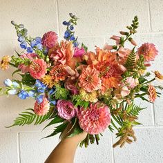 a vase filled with lots of different colored flowers