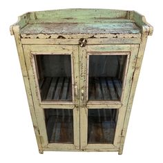 an old wooden cabinet with glass doors on the top and bottom shelf is painted green