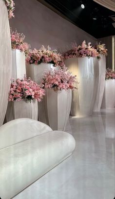 several large white vases with pink flowers in them