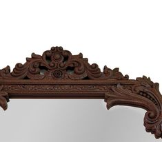 an ornate wooden mirror is shown against a white background