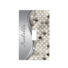 an elegant light switch cover with white and gold fish scales on the front, and silver accents