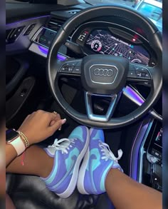 a woman sitting in the driver's seat of a car with her feet on the steering wheel