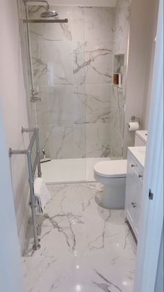 a white bathroom with marble floors and walls