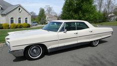 an old white car is parked on the street