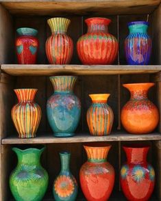 many different colored vases sitting on shelves