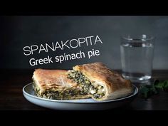 a plate with some food on it and a glass next to it that says spanakopita greek spinach pie