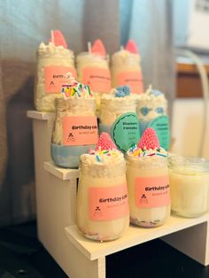 small jars filled with different types of desserts sitting on a shelf next to each other