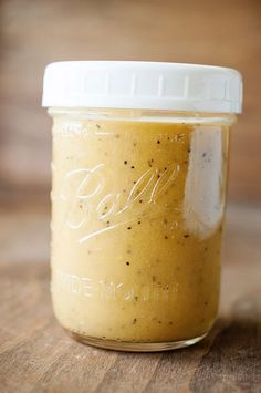 a jar filled with mustard sitting on top of a wooden table