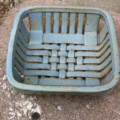 an old blue basket sitting on the ground