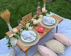 the table is set with plates, silverware and other items for an outdoor event