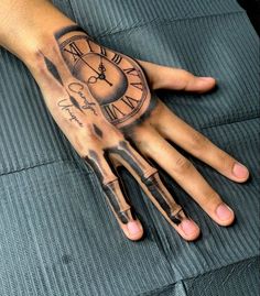 a person's hand with a clock tattoo on it