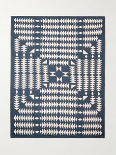 a blue and white rug with an intricate design on the front, featuring arrows in different directions