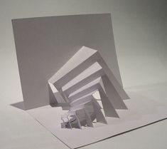 an abstract white paper sculpture on top of a table