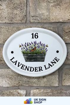 a sign on the side of a brick wall that says lavender lane with flowers in a pot