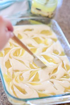 someone using a spatula to dip sauce in a casserole dish