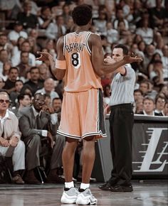 a basketball player is standing on the court with his hands out to someone in front of him