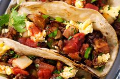 two tacos filled with meat and vegetables on a plate