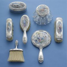 an assortment of antique silver items including brush, mirror and soap dispenser