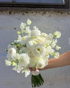 a person holding a bouquet of white flowers