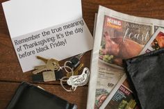 a wallet, keys, and other items are on the table next to a note