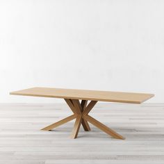 a wooden table sitting on top of a hard wood floor next to a white wall