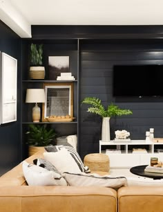 a living room filled with furniture and a flat screen tv mounted to the side of a wall