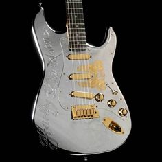 a silver guitar with gold hardware on it