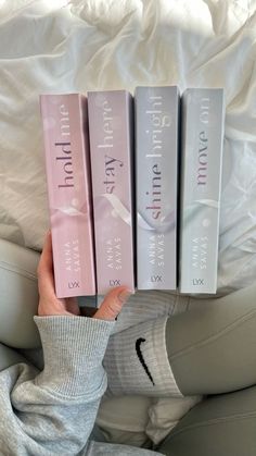 a person holding three books in their hands