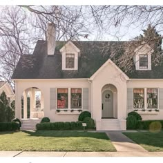 a white house with gray shingles and windows