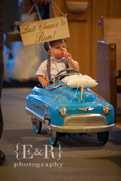 a little boy sitting in a toy car with a sign that says last chance to buy