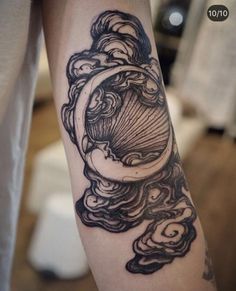 a person with a tattoo on their arm that has clouds and a clock in it