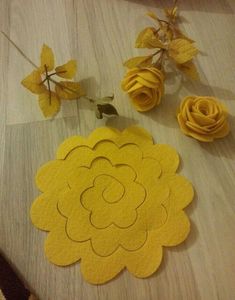 some yellow flowers are sitting on the floor next to each other and one is cut out from felt