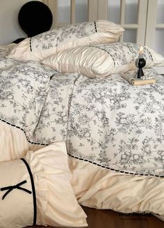 an unmade bed with black and white comforter, pillows and pillowcases