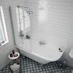 a white bathtub sitting next to a window in a bathroom with black and white tile